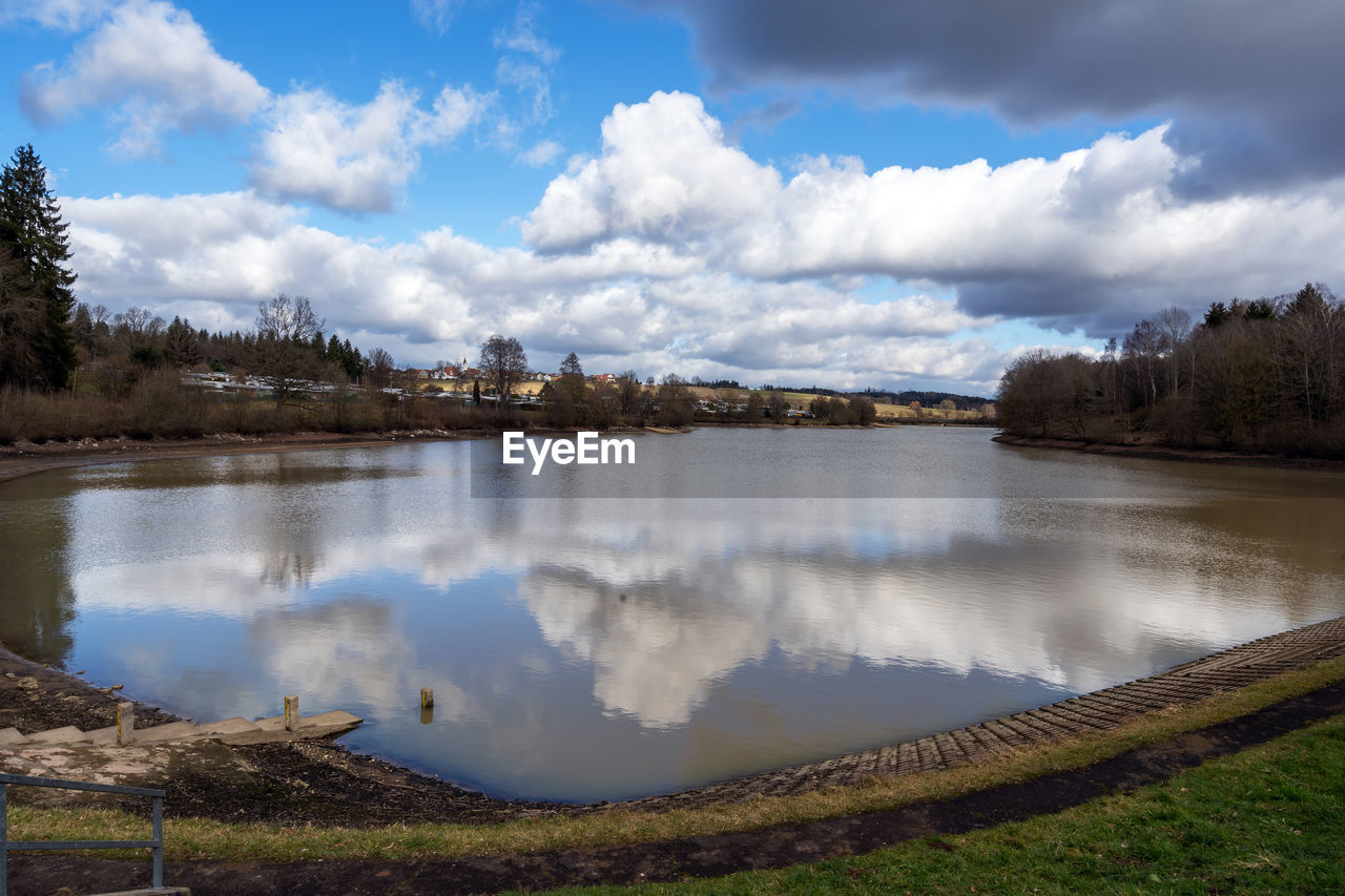 reflection, water, cloud, nature, sky, body of water, reservoir, environment, lake, landscape, scenics - nature, tree, plant, beauty in nature, travel destinations, land, morning, no people, travel, mountain, tranquility, tourism, wilderness, outdoors, forest, tranquil scene, grass, blue, rural area, non-urban scene, day, shore, architecture