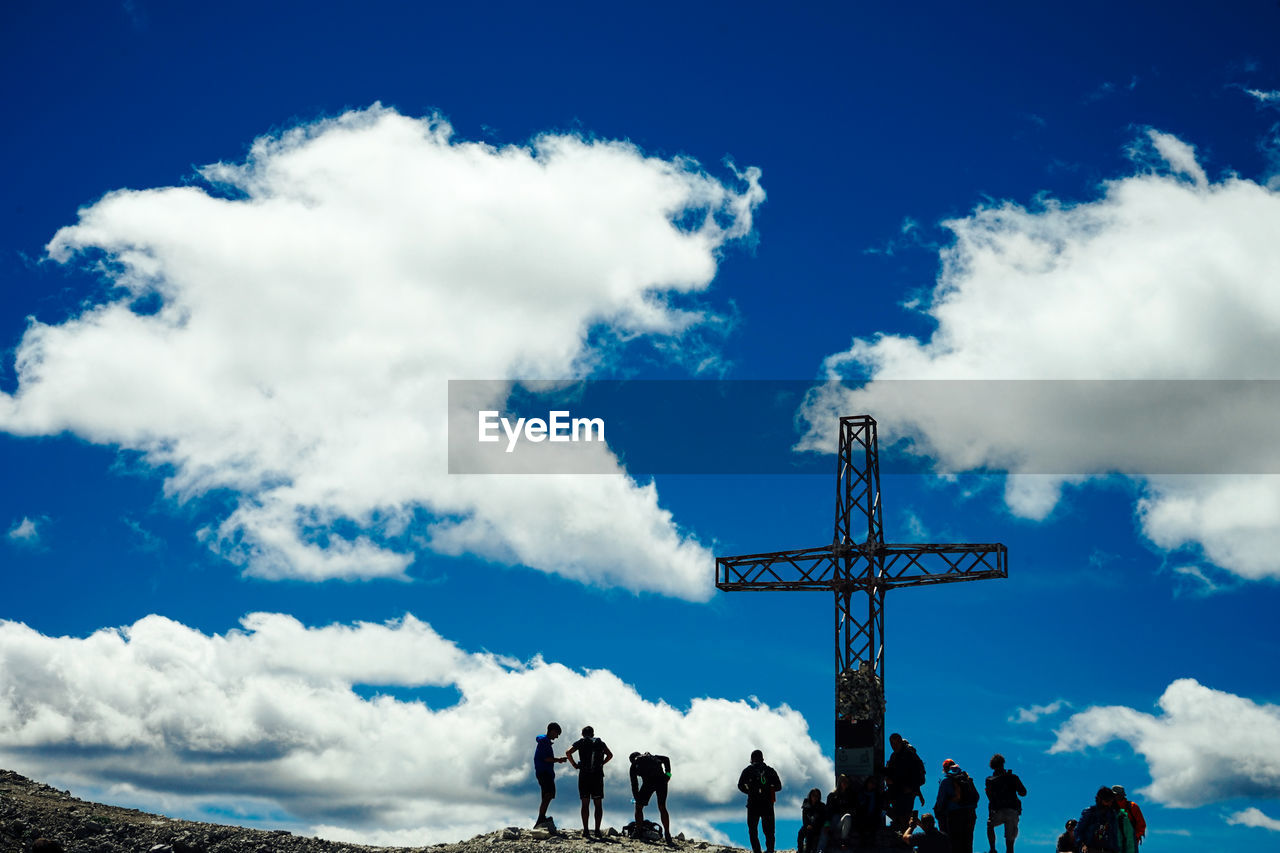 LOW ANGLE VIEW OF PEOPLE WALKING AGAINST SKY