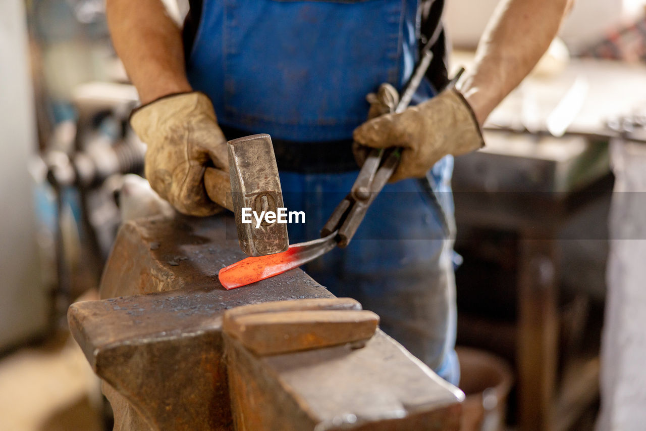 Close up view of heated metal and anvil. the blacksmith in the production process of metal products