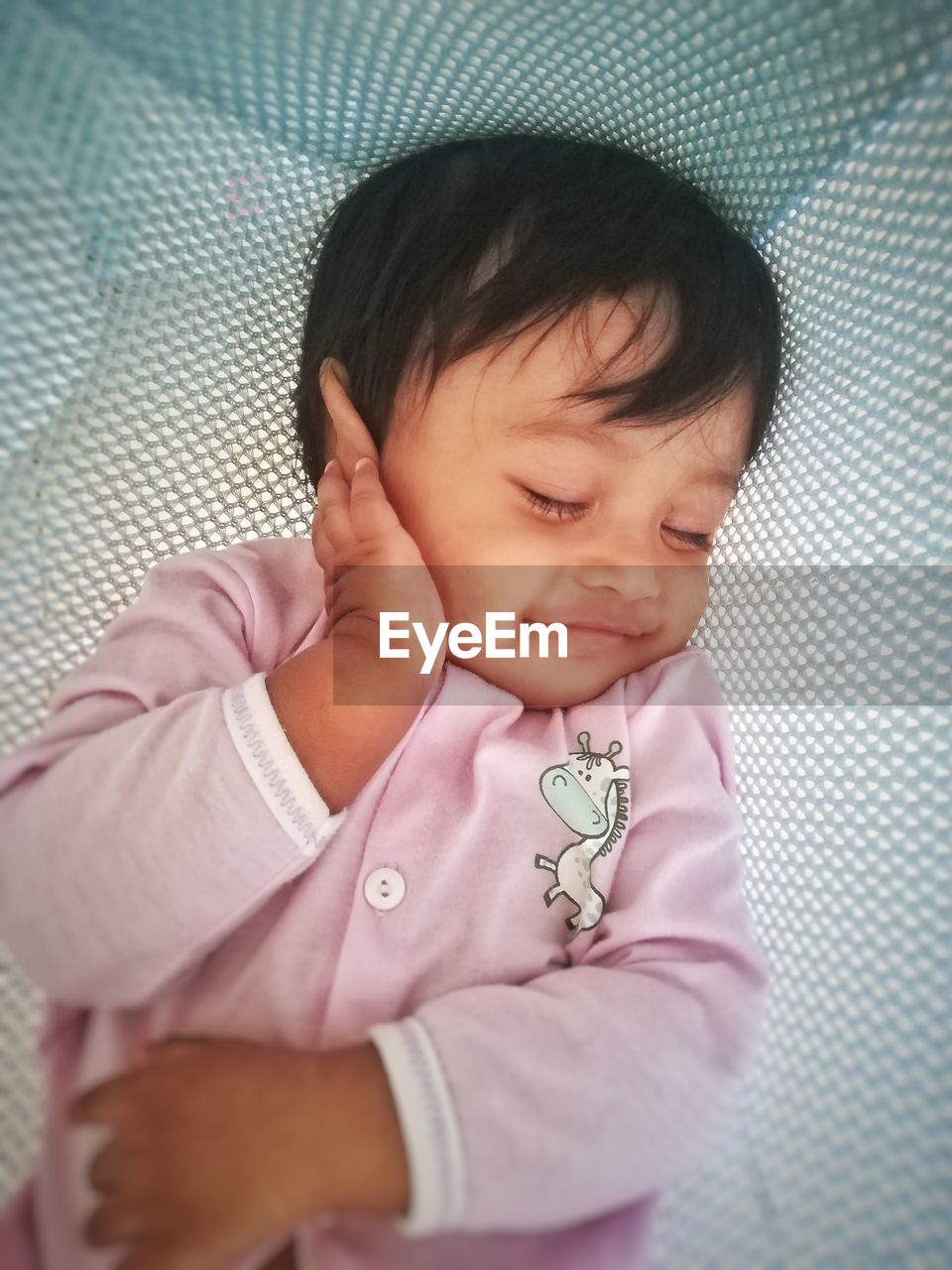 High angle view of cute baby boy sleeping in crib