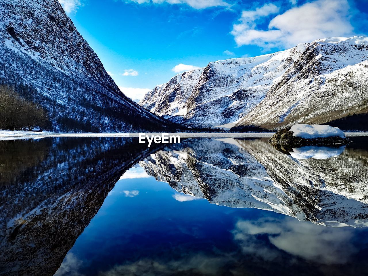 Scenic view of lake and snowcapped mountains against sky