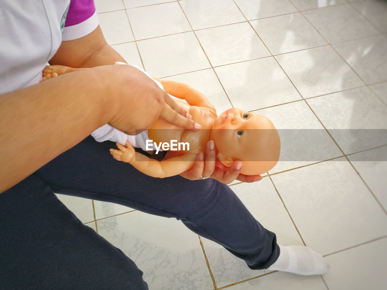 Low section of paramedic practicing on cpr dummy