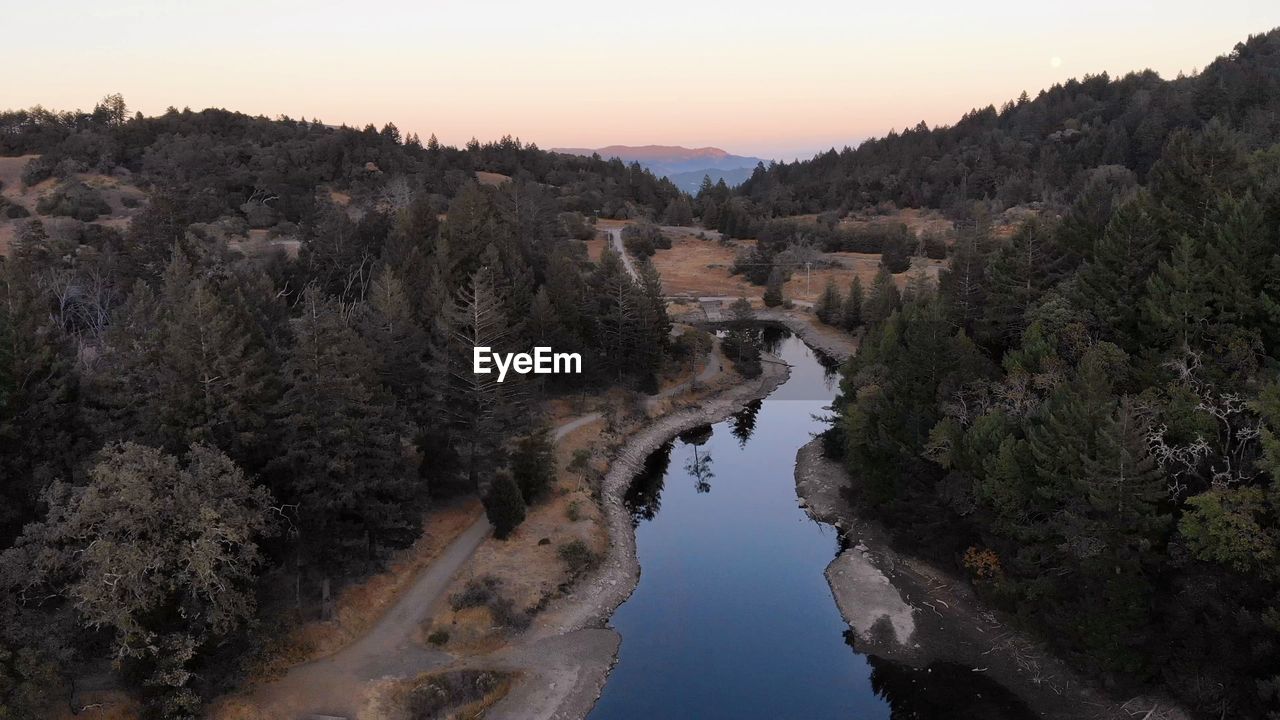 High angle view of river amidst trees against sky
