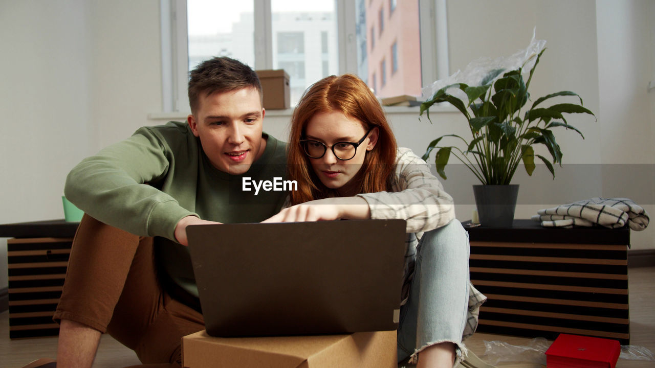 Young couple using laptop at home