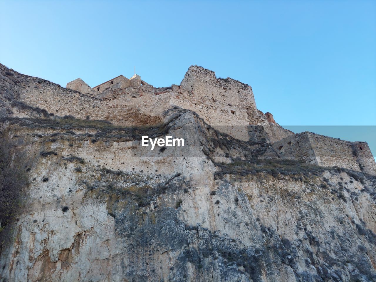 sky, rock, mountain, nature, environment, landscape, scenics - nature, clear sky, blue, beauty in nature, geology, no people, rock formation, land, ridge, travel destinations, mountain range, non-urban scene, outdoors, travel, terrain, day, cliff, sunny, extreme terrain, desert, plateau, tranquility, formation, summit