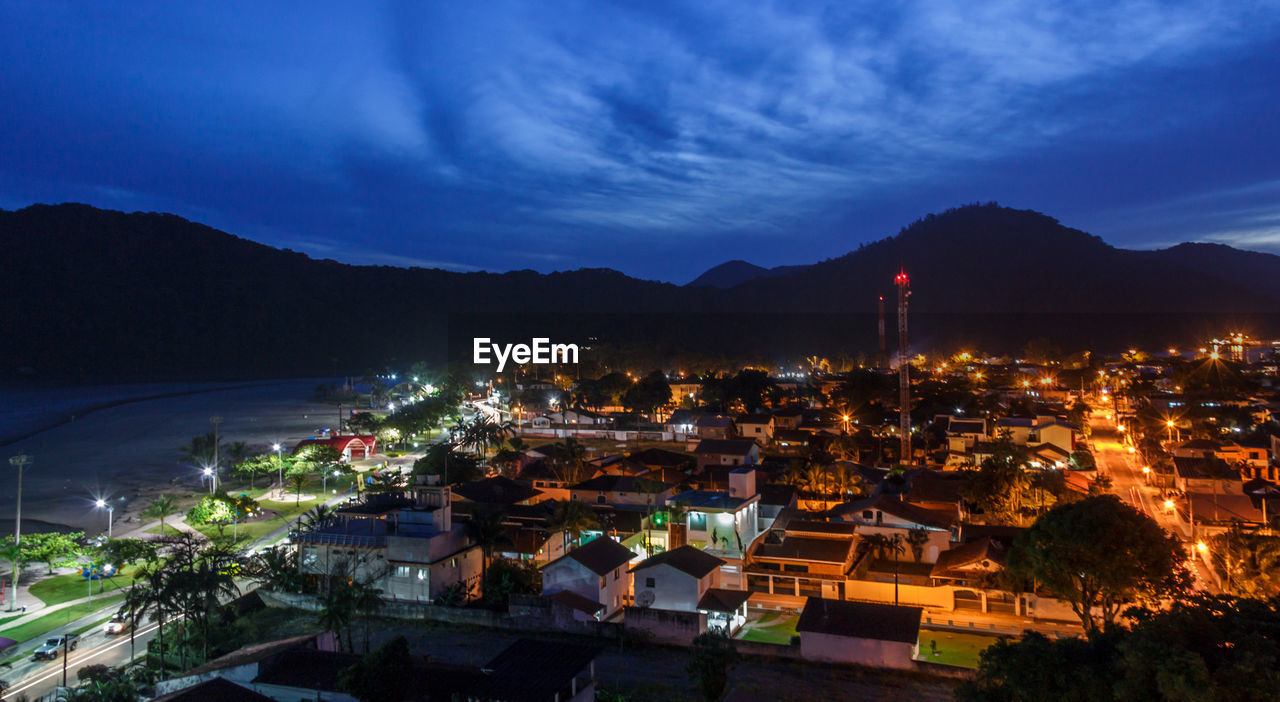 High angle view of illuminated town against sky at night