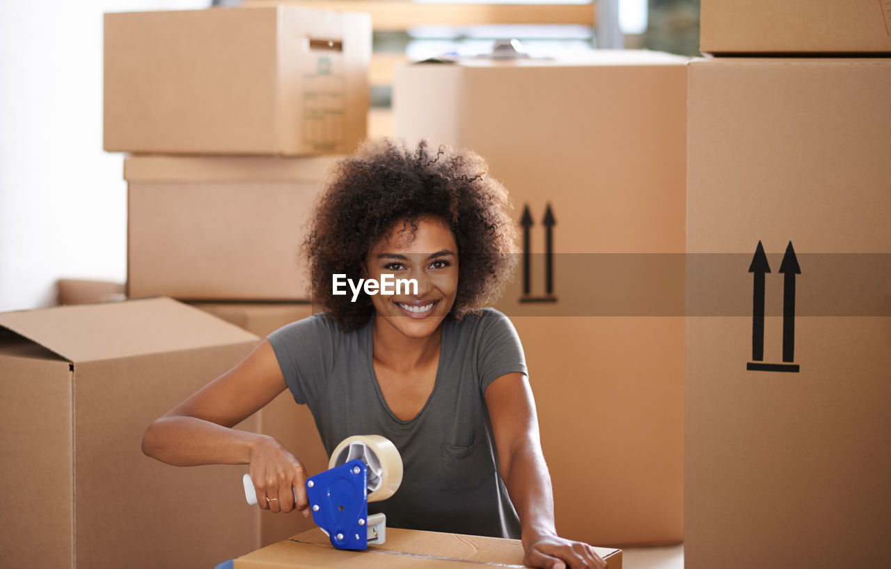 Smiling woman packing boxes at home