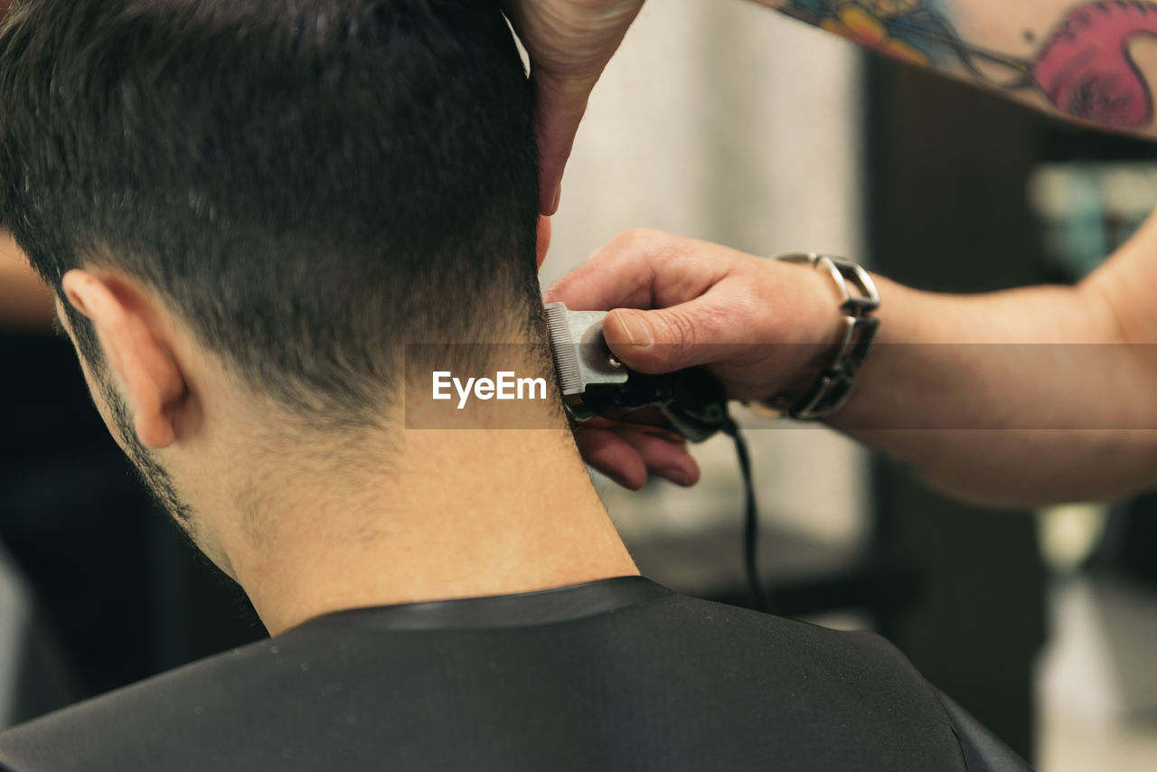 Hairdresser cutting man hair