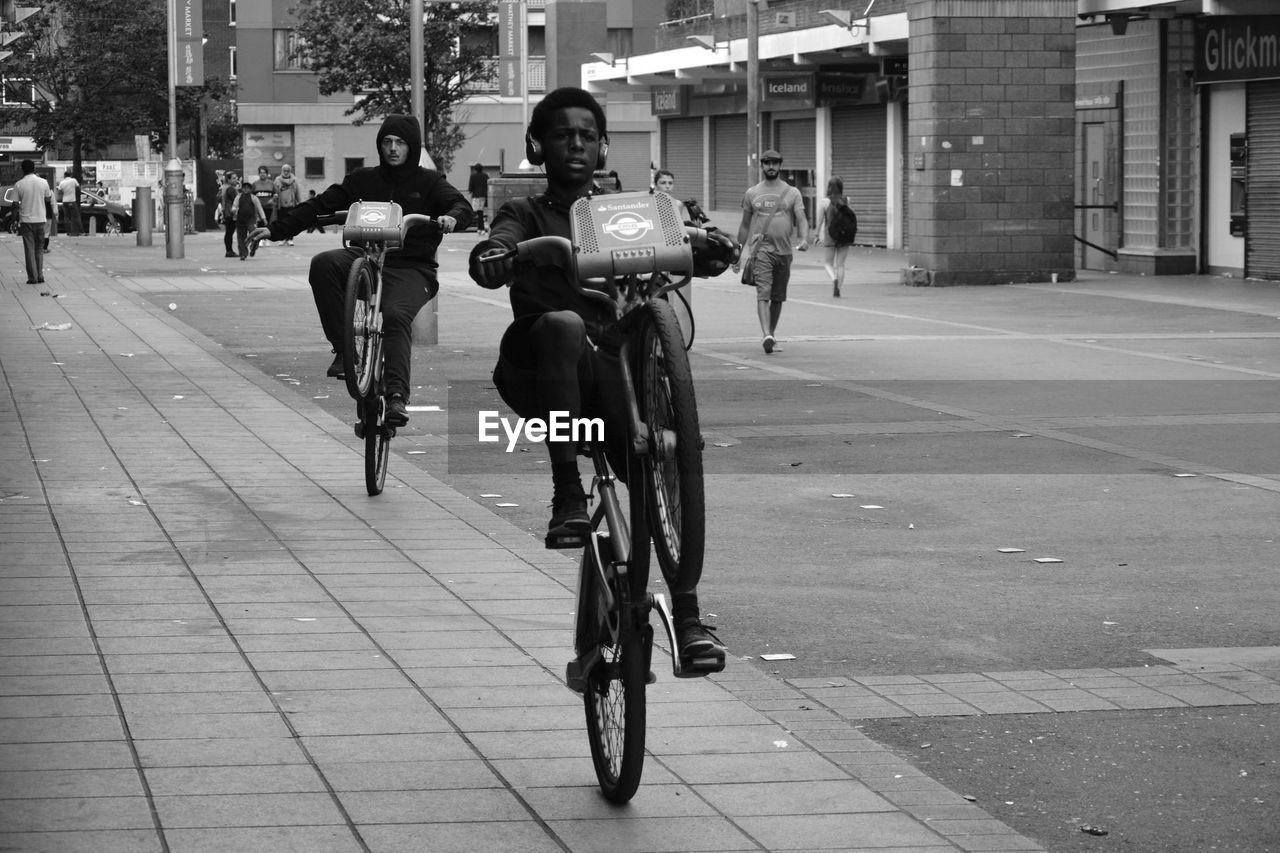 PEOPLE RIDING BICYCLE ON CITY