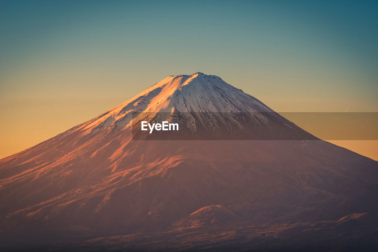 Scenic view of snowcapped mountains against sky during sunset