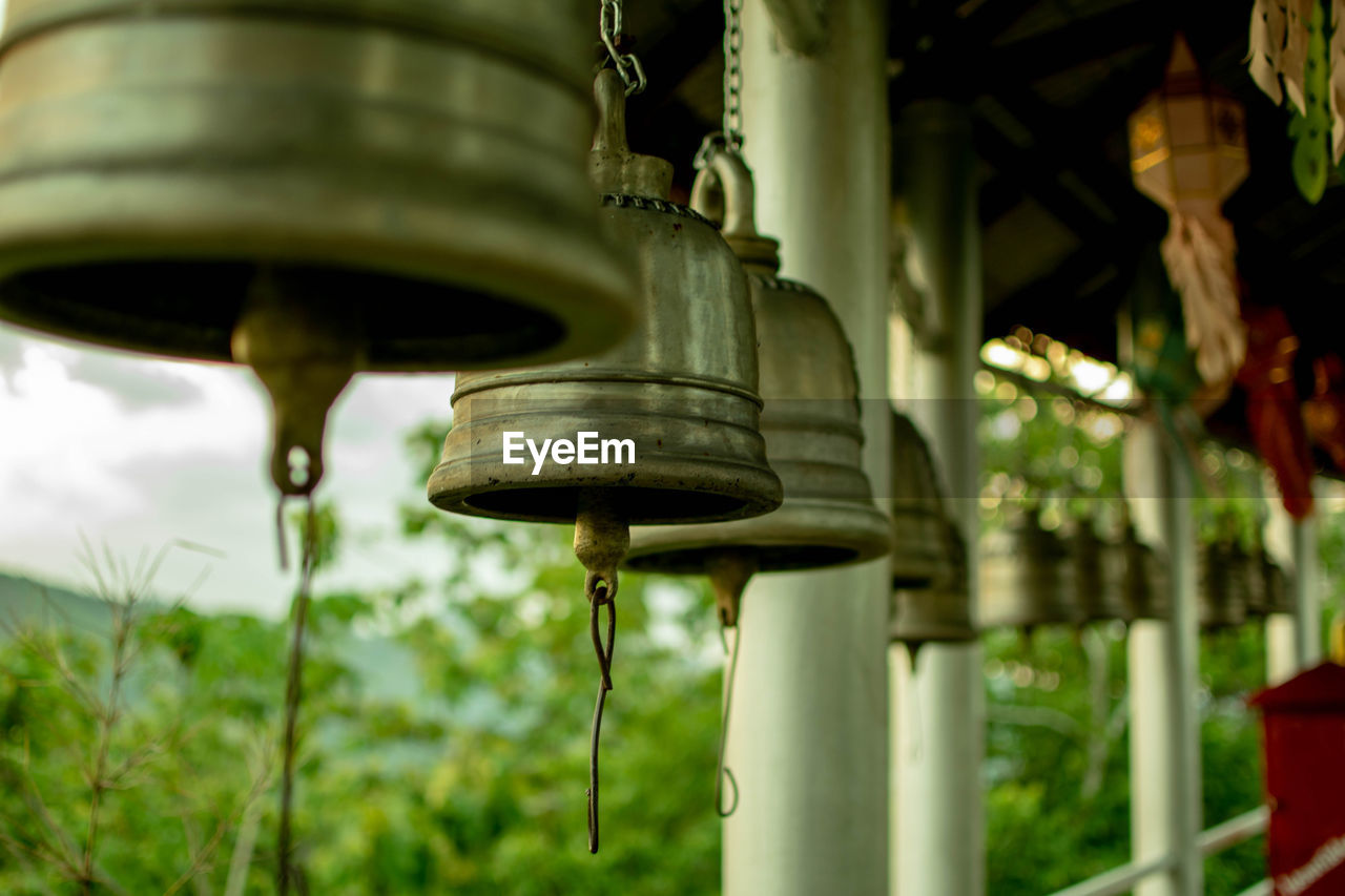 LOW ANGLE VIEW OF BELL HANGING BY METAL STRUCTURE