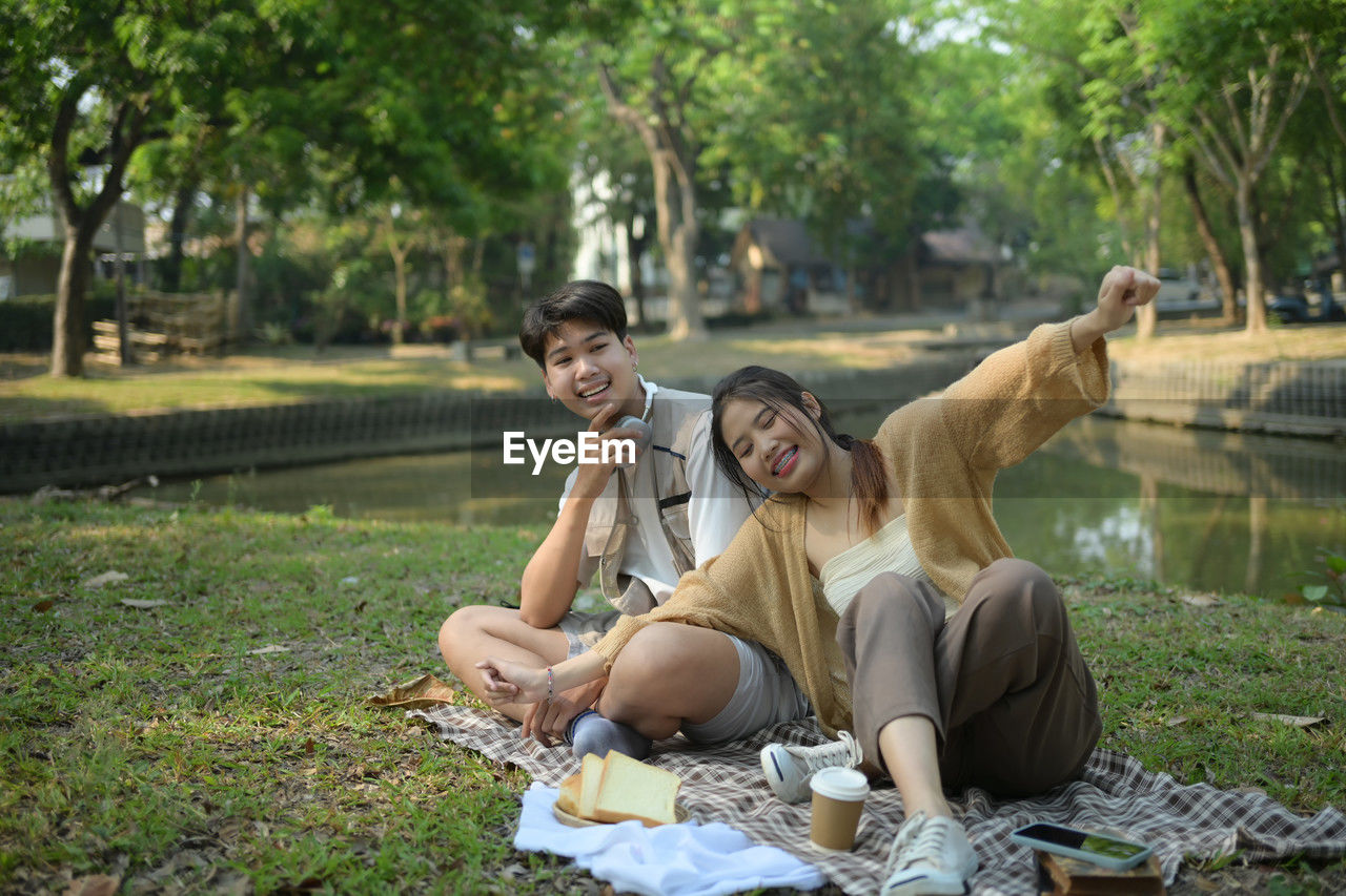 side view of woman sitting on field in park