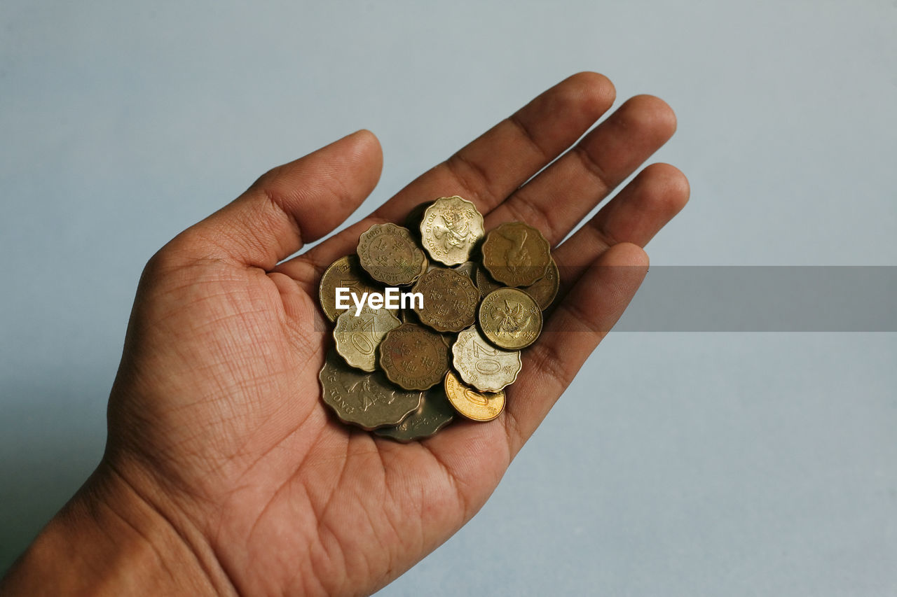 hand, finance, coin, currency, money, business, holding, wealth, one person, savings, close-up, studio shot, cash, investment, finance and economy, indoors, large group of objects, adult, money handling, business finance and industry, gray background, banking, economy, finger