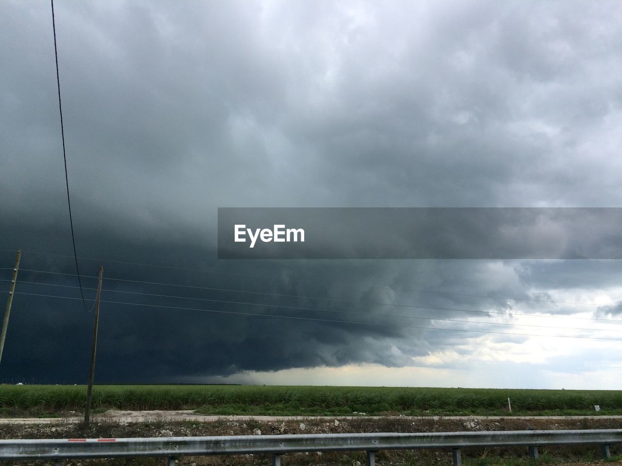 Storm clouds gathering over flat green field