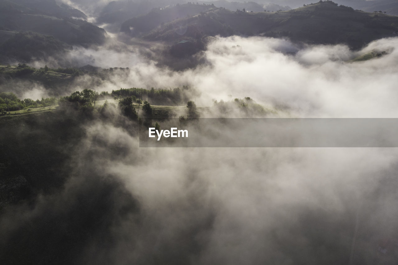 HIGH ANGLE VIEW OF TREES AND MOUNTAINS AGAINST SKY