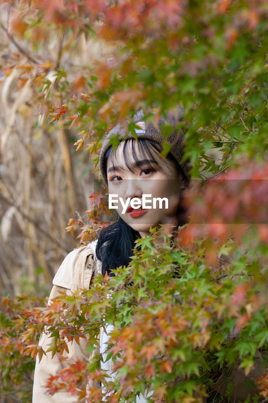 Portrait of beautiful woman standing plants