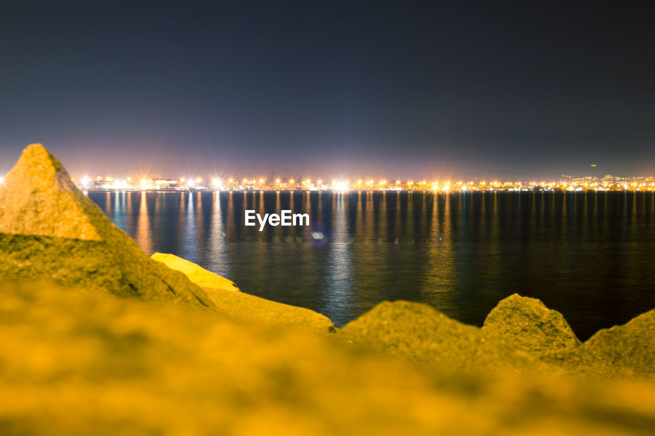 Scenic view of lake against sky at night