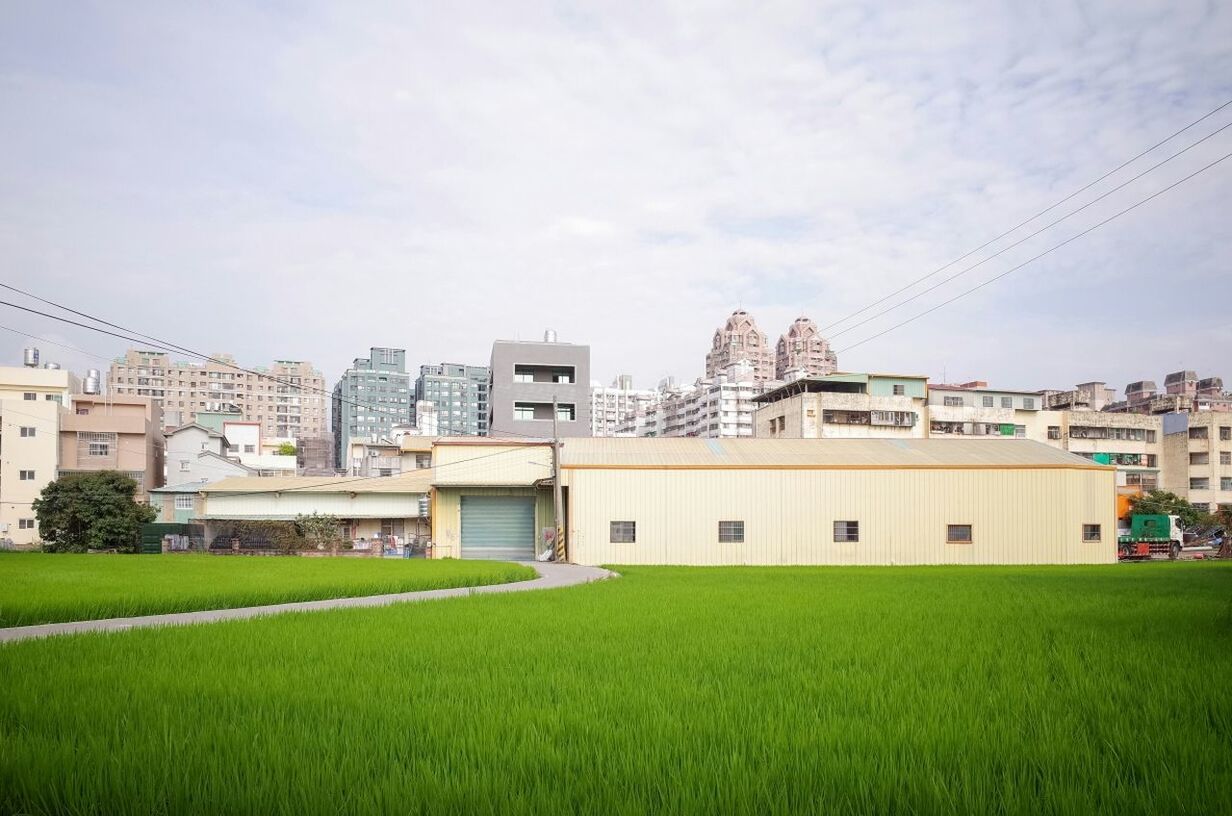 Buildings against sky with grassland in foreground