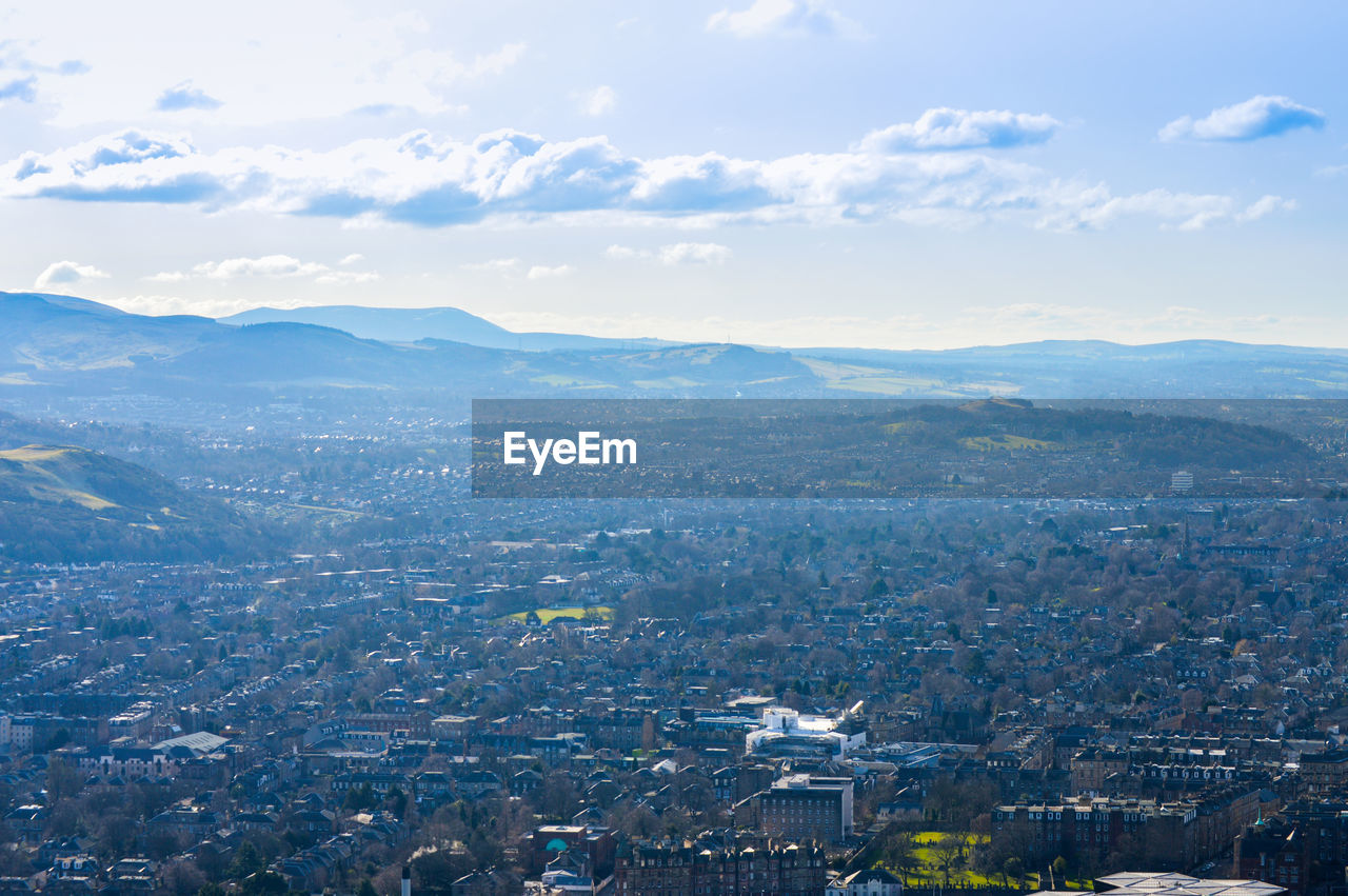 HIGH ANGLE VIEW OF CITYSCAPE AGAINST MOUNTAIN RANGE