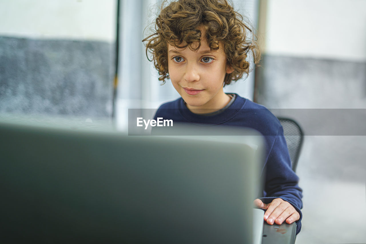 Schoolboy age children using laptop in the courtyard. online video call meeting schools 