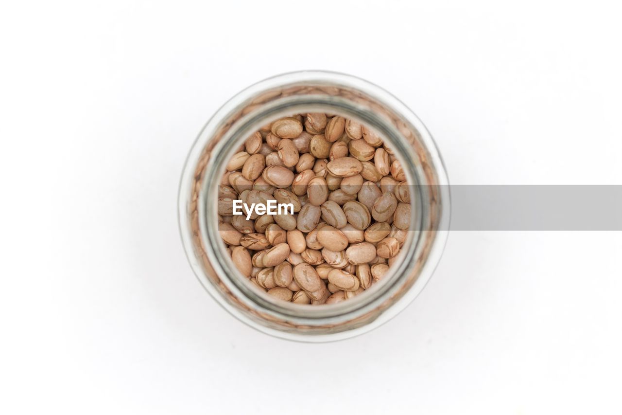 Directly above shot of raw food in jar on white background