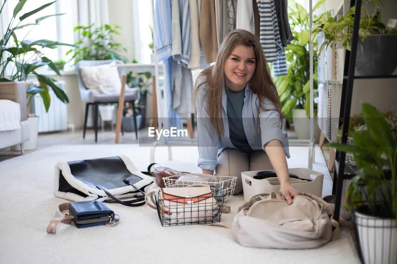 portrait of young woman using mobile phone while sitting at home