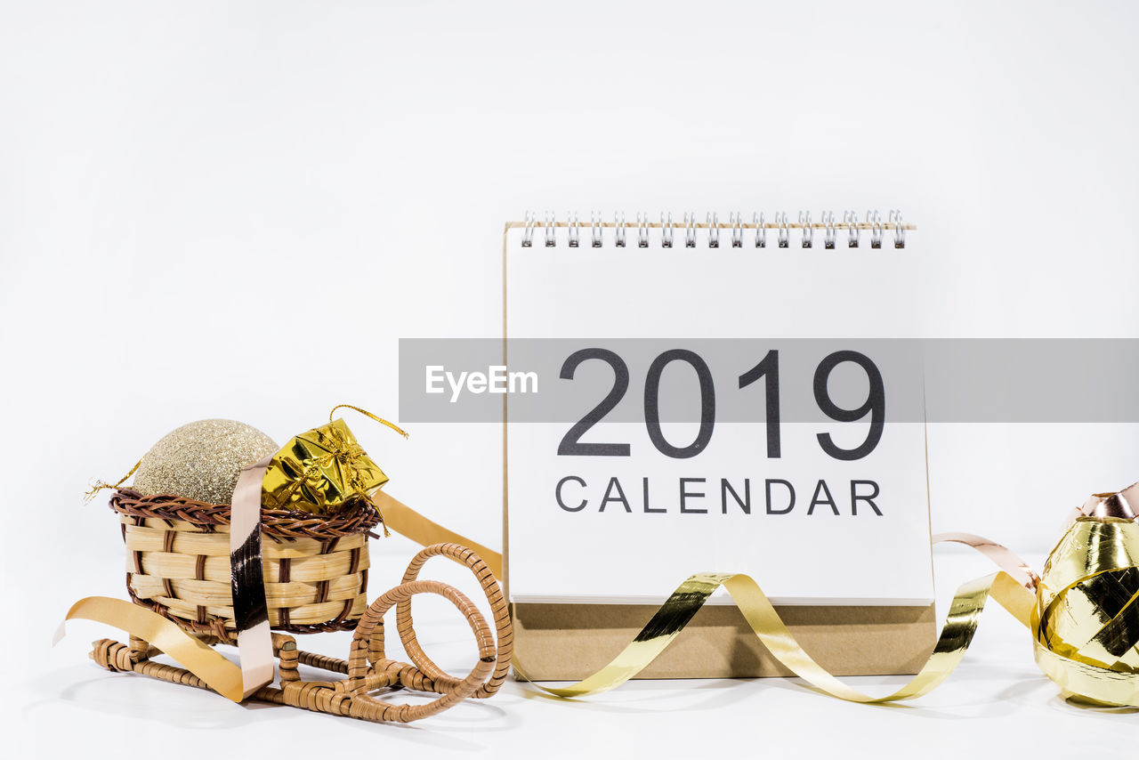 Close-up of calendar with ribbon on white background