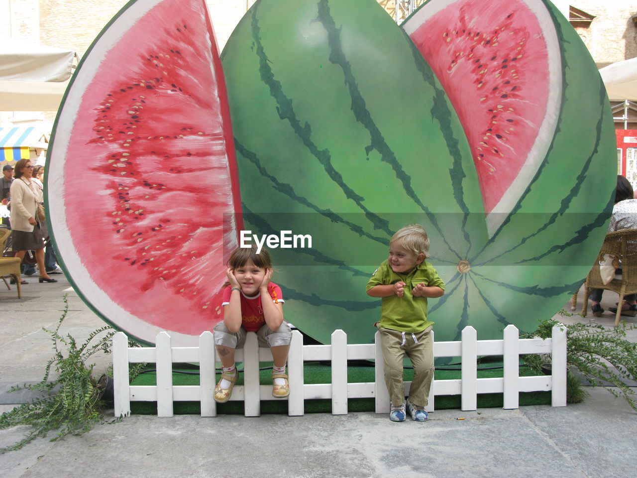 Full length of friends against large watermelon model