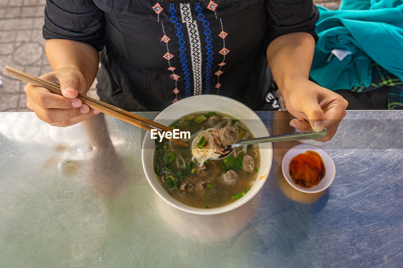 MIDSECTION OF WOMAN HOLDING FOOD