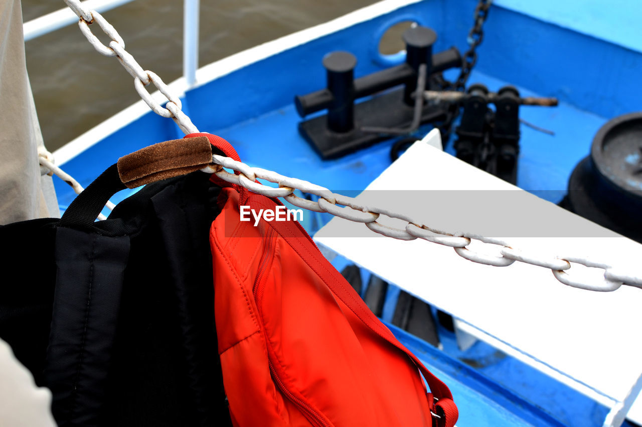 CLOSE-UP OF CLOTHES DRYING ON ROPE AGAINST BOAT