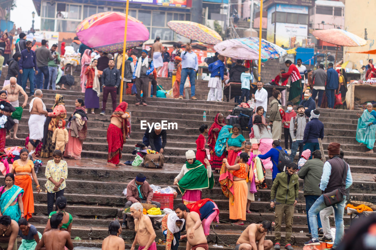 crowd, large group of people, group of people, architecture, umbrella, city, women, adult, men, street, lifestyles, day, city life, building exterior, outdoors, leisure activity, built structure, protection, market, celebration, crowded, event, walking, nature, person, high angle view, mixed age range, travel destinations