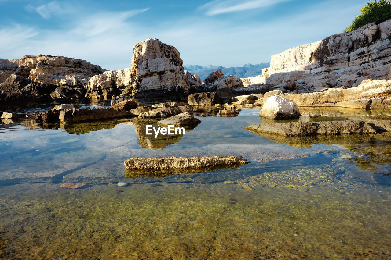 Scenic view of rock formation in lake against sky