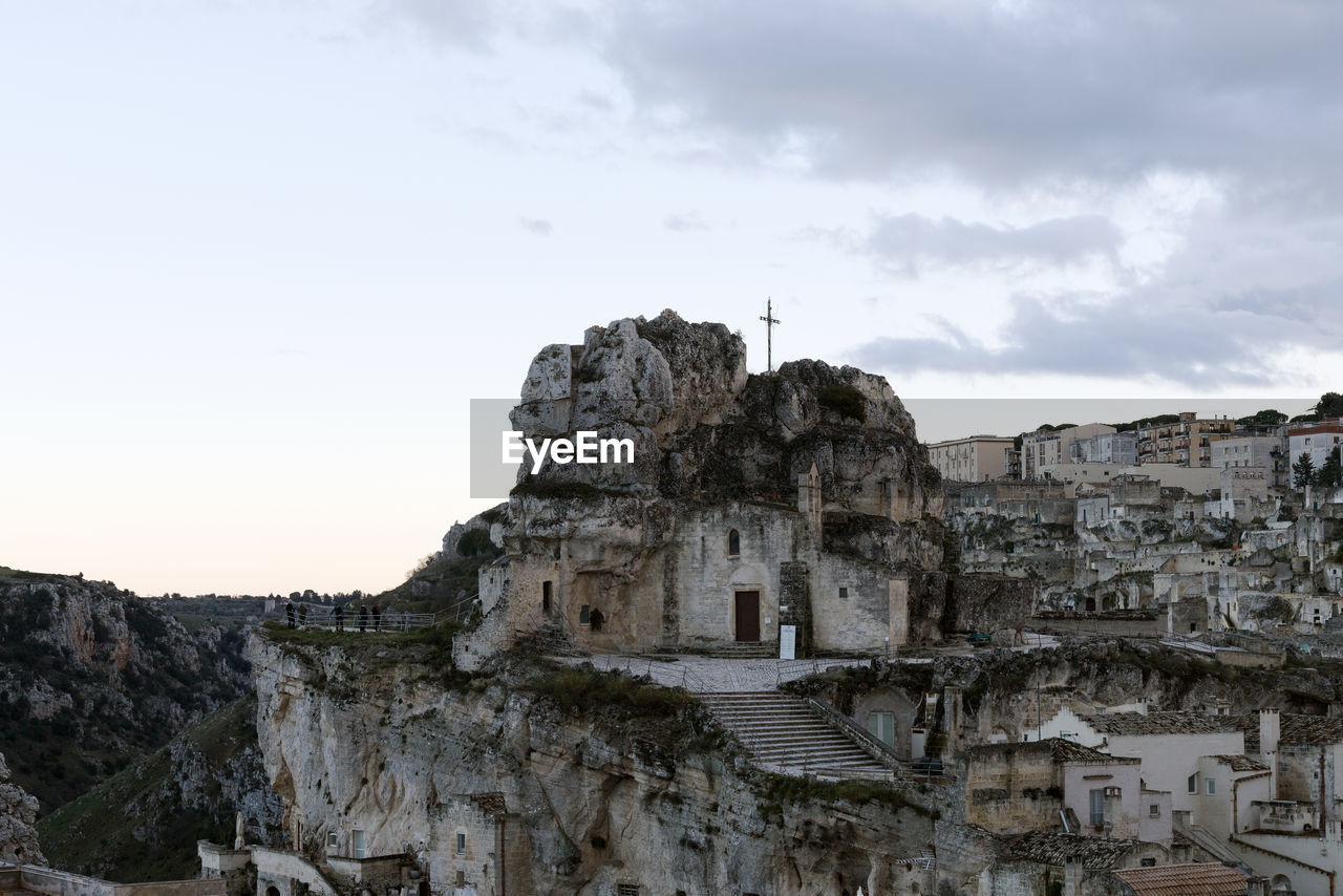 ruins, architecture, sky, ancient history, history, rock, travel destinations, nature, the past, travel, built structure, temple, cloud, building, ancient, no people, landmark, building exterior, tourism, outdoors, religion, environment, mountain, land, stone material, terrain, old ruin, archaeological site, temple - building, rock formation, landscape, cliff, day