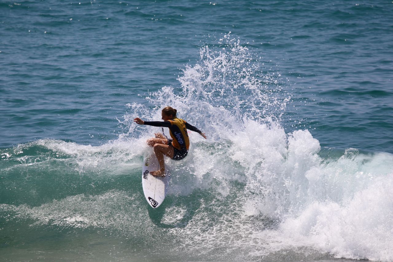 MAN SURFING ON SEA WAVES