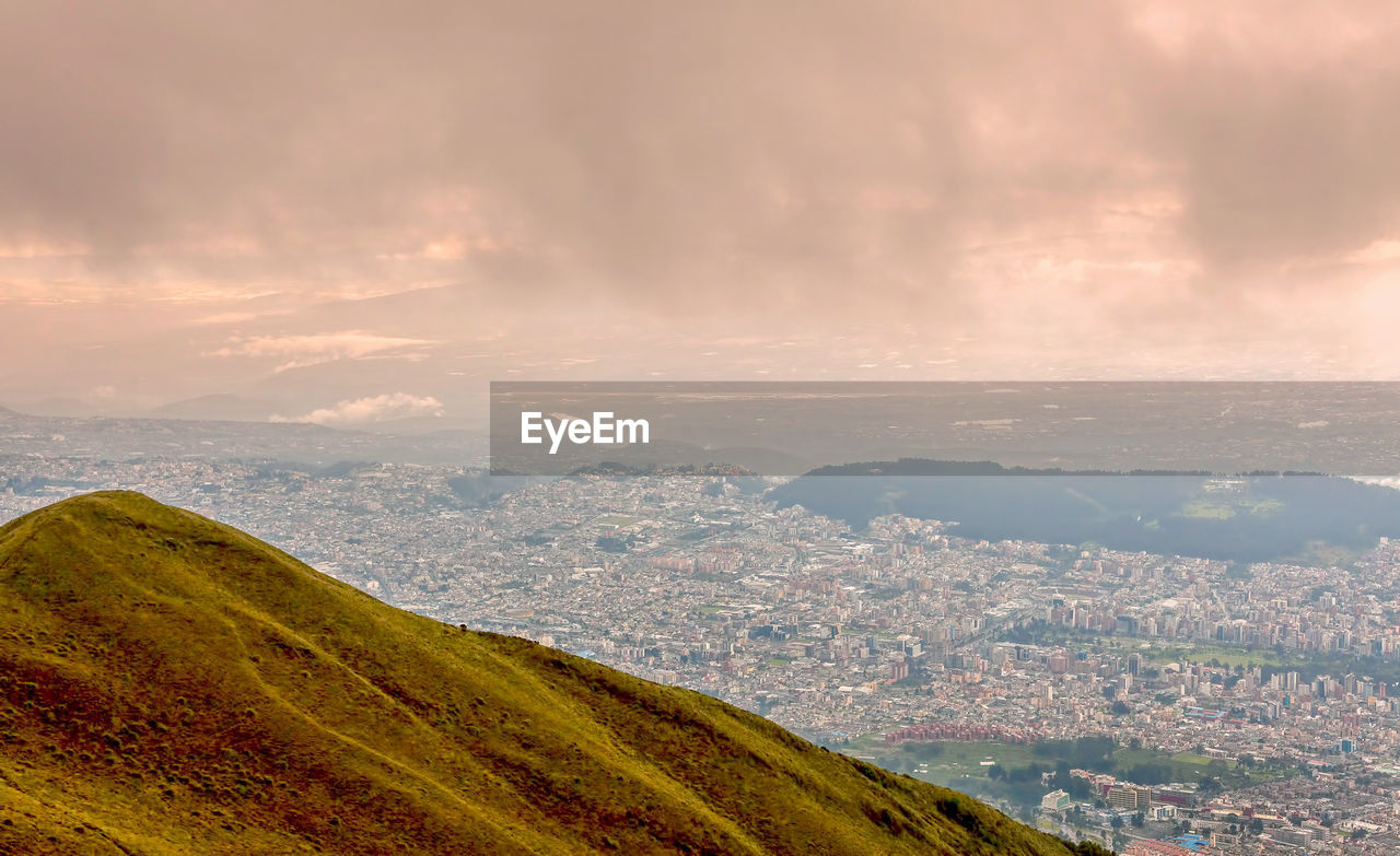 Aerial view of city by sea against sky