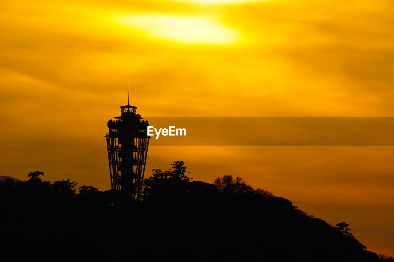 SILHOUETTE TOWER AGAINST ORANGE SKY