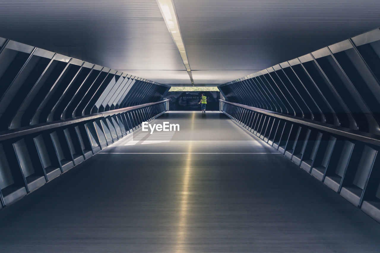 VIEW OF EMPTY SUBWAY WITH CEILING AND FOOTBRIDGE