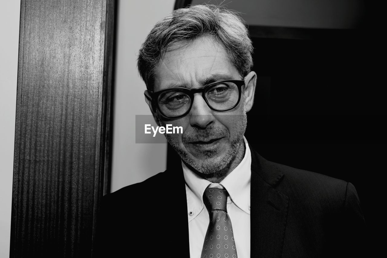 Close-up of mature man wearing suit and eyeglasses looking away