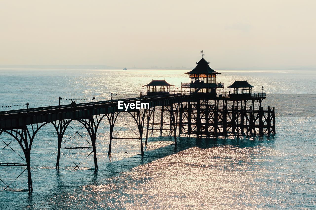 Scenic view of pier and sea against sky during sunset