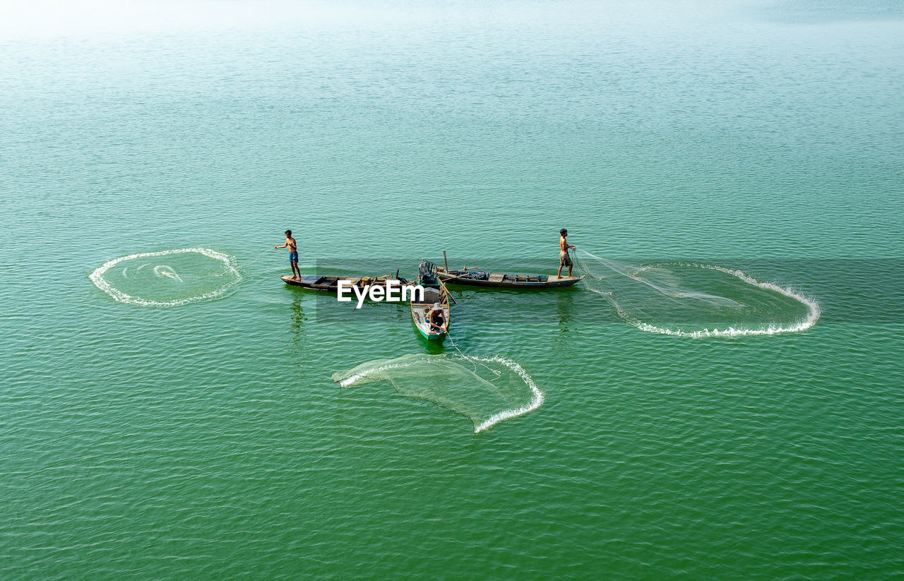 High angle view of people fishing on boat in sea