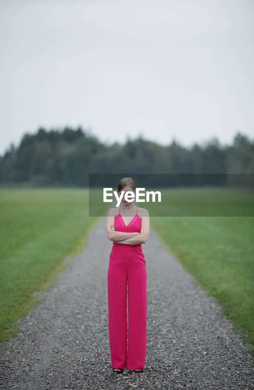 rear view of woman sitting on field against clear sky