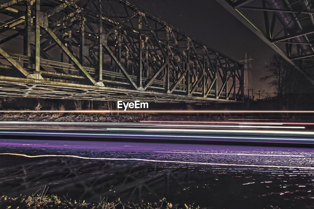 LIGHT TRAILS ON BRIDGE IN CITY