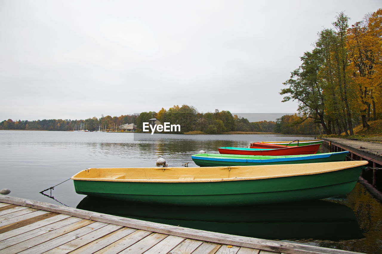 Old wooden boats near the beach of trakai gavle lake, lithuania. autumn and fall time.