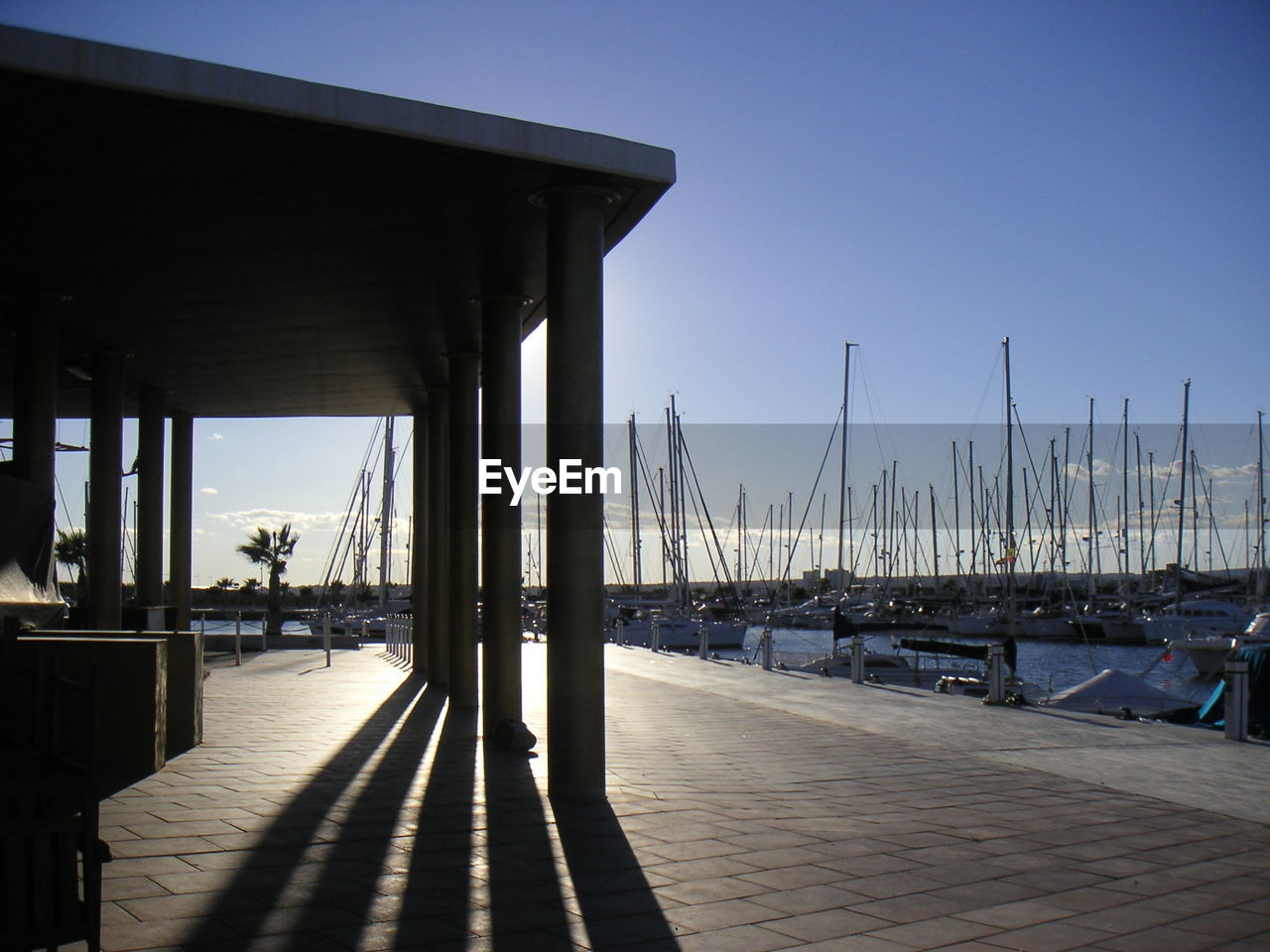 Walkway by sailboats moored at harbor