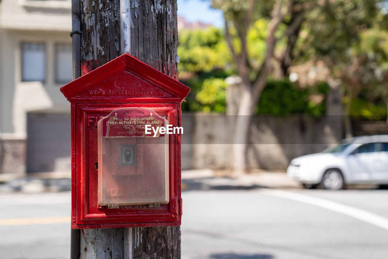 CLOSE-UP OF RED MAILBOX ON STREET