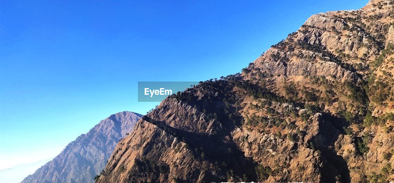 LOW ANGLE VIEW OF ROCK FORMATION AGAINST CLEAR SKY