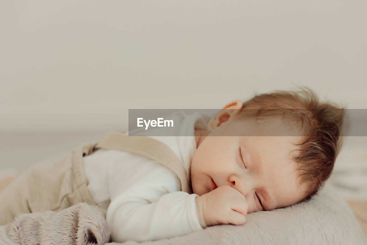 Cute baby girl sleeping on bed at home