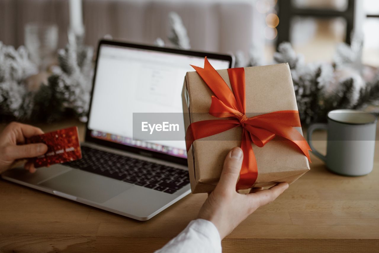 Cropped hand of woman shopping online at home