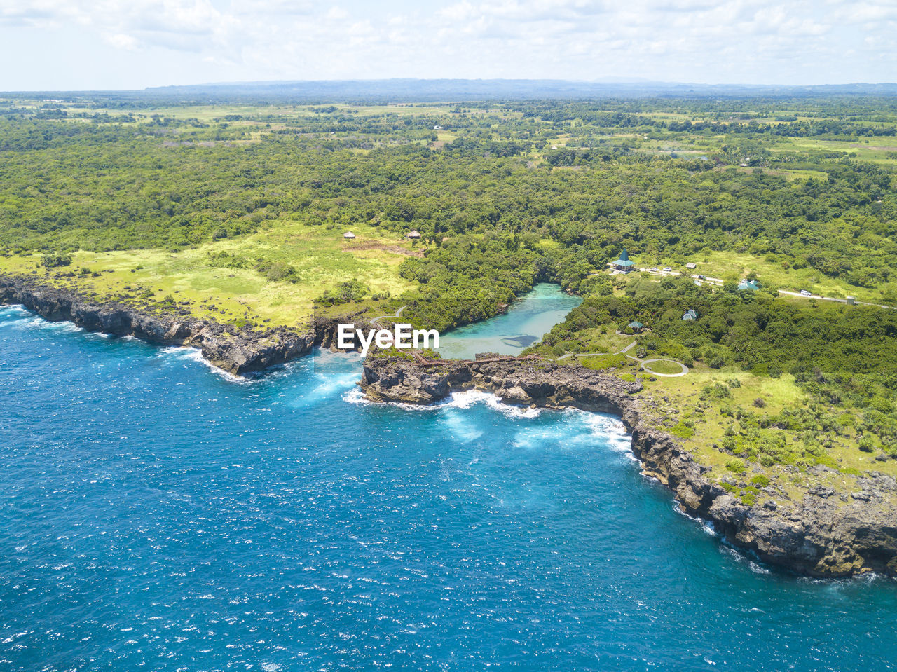 Aerial view of island against sky during sunny day