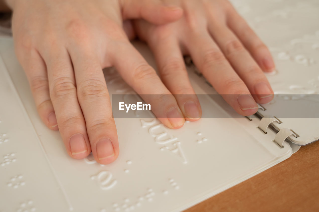 Cropped image of person reading braille language